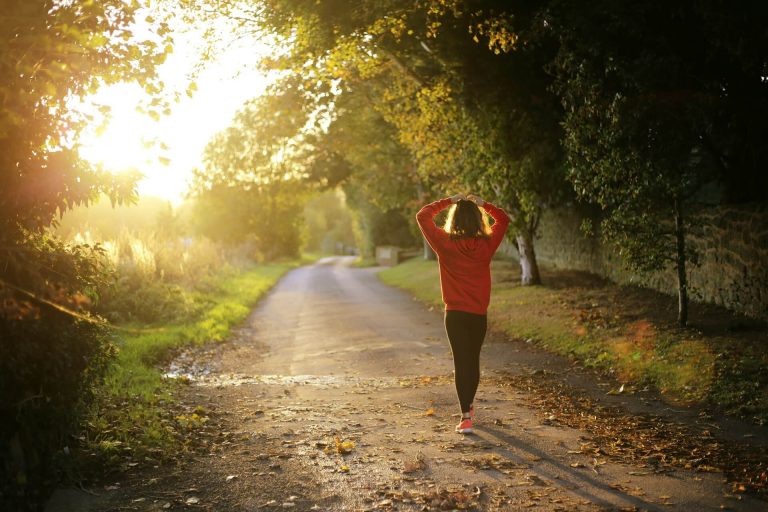 Women walking during a run, with her hands on her head
