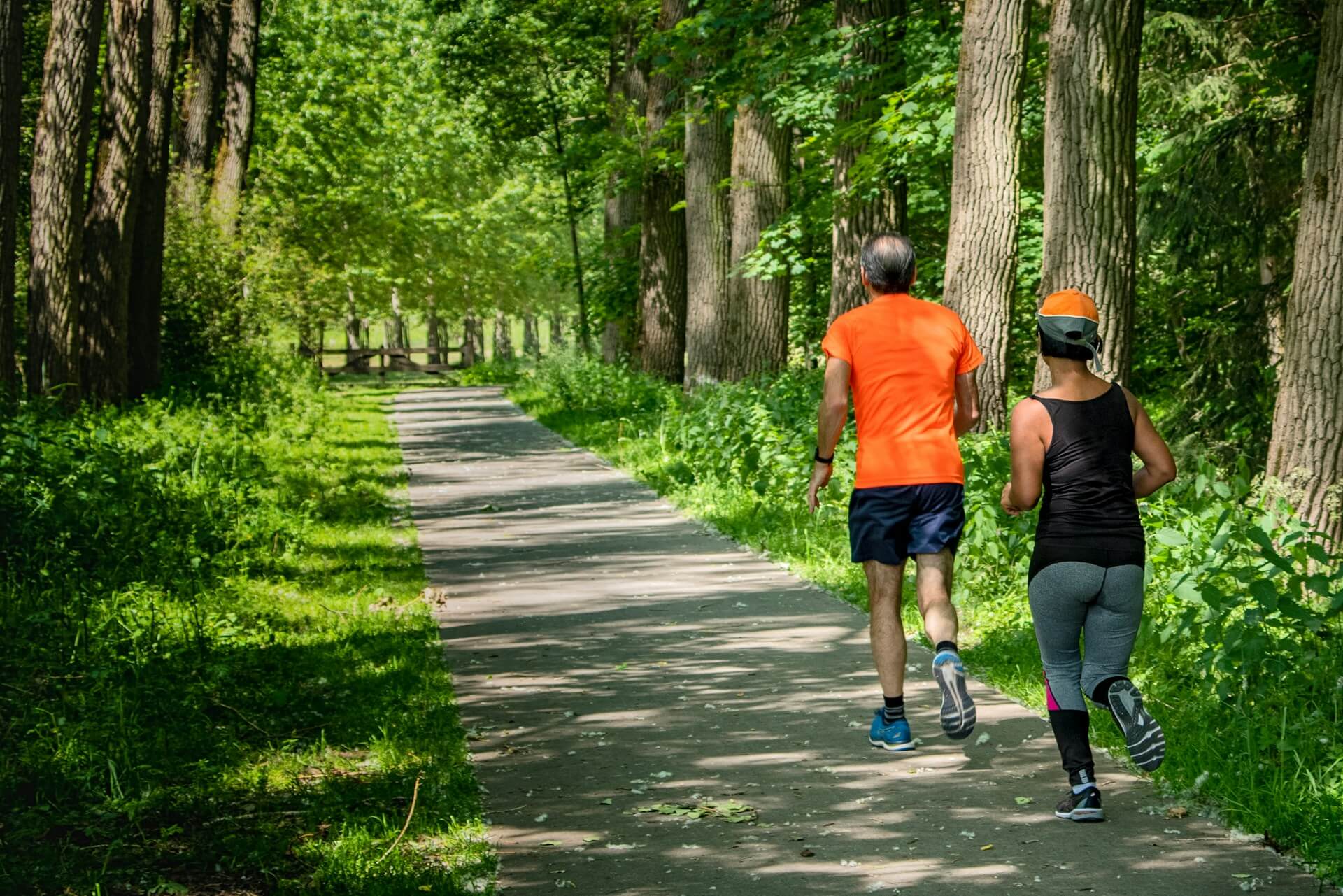 Man and woman running in a forest doing the couch to 5k training plan