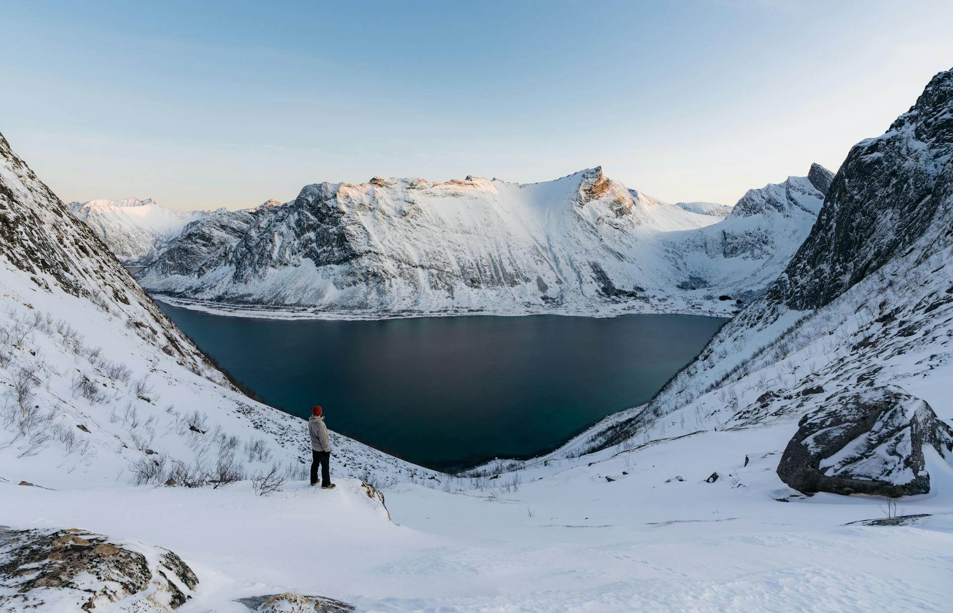 Man stood in the mountains in Norway, near a lake
