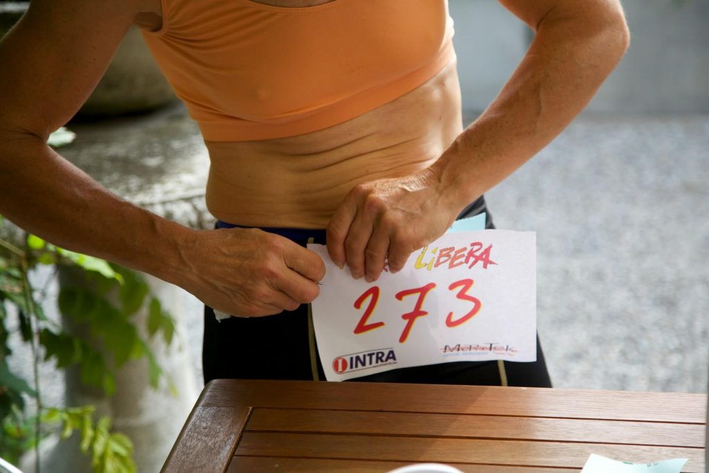 uk marathon tips for beginners - runner pinning on race number on race day morning