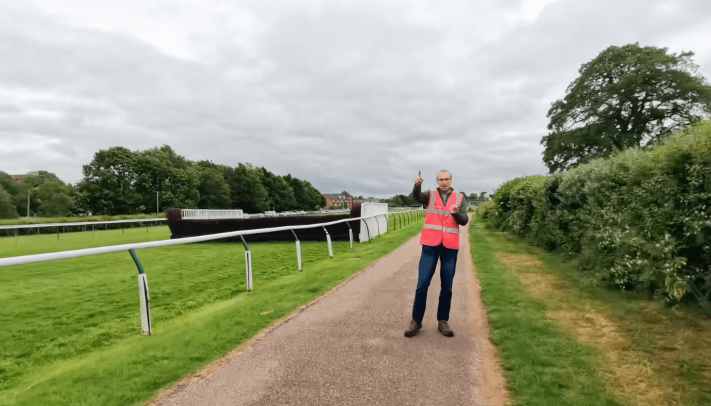 parkrun volunteer roles marshal in a hi-vis vest pointing runners in the right direction